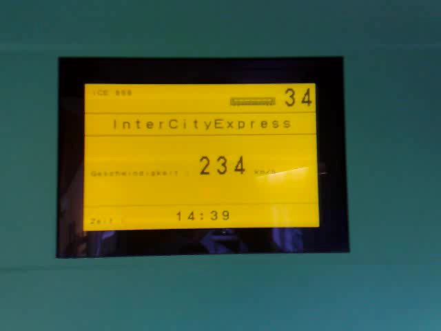 Screenshot2.png - A to już następna podróż: z Berlina do Trier przez Kolonię. Ostatnio byłem nieco zawiedziony, że ICE do Monachium jechał niewiele szybciej, niż zwykłe pociągi ot chociażby w Polsce. Ten do Kolonii (to był akurat ICE I generacji) też był niewiele szybszy... Tak mi się przynajmniej wydawało, dopóki nie poszedłem skorzystać z toalety. Idąc, spojrzałem na monitorek przy drzwiach, wyświetlający aktualną prędkość, i dopiero wówczas się przekonałem, że jednak jdziemy znaaaacznie szybciej, niż sądziłem [stopklatka z filmu]
